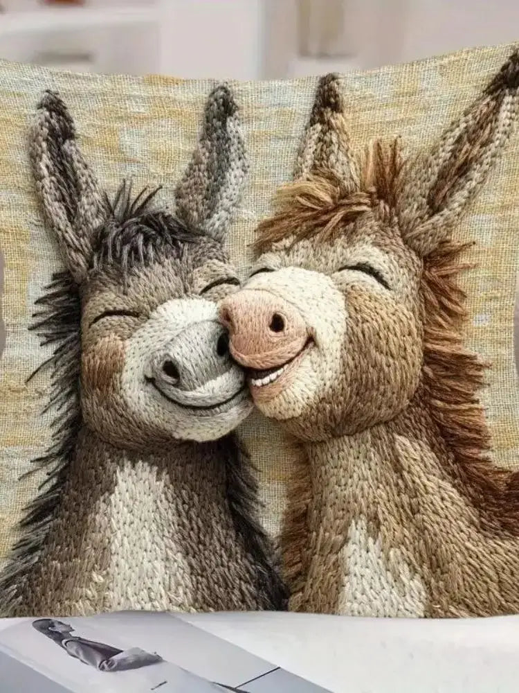 A knitted pillow cover featuring two adorable cartoon donkeys with expressive faces.