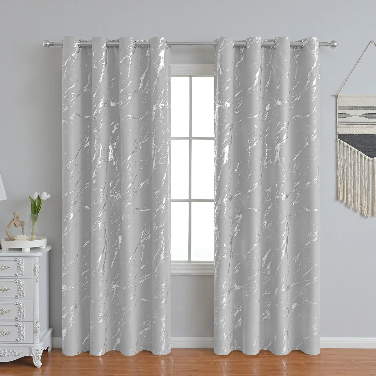 Modern marble printed curtain in gray and white with silver stamping hanging in a window.