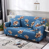 A blue floral patterned universal stretch sofa slipcover displayed indoors against a white wall.