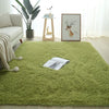 A bright green plush area rug with a fluffy texture placed on a light wooden floor.