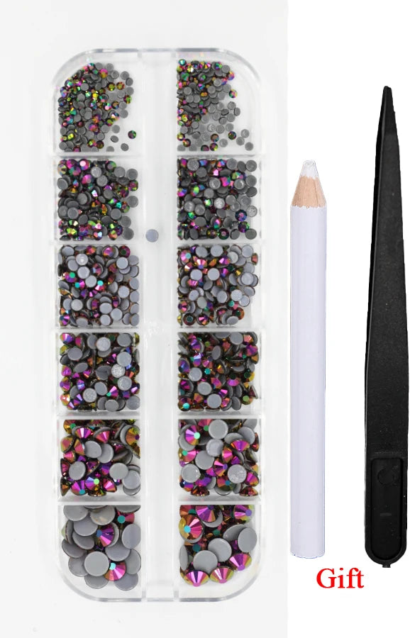 A clear plastic container holds a set of iridescent and dark colored rhinestones with an applicator tool.