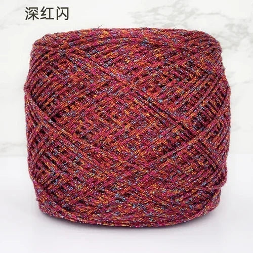 A ball of metallic silk crocheting and knitting yarn in a deep reddish-pink color.