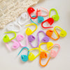 A collection of colorful plastic stitch markers in various shapes and colors for knitting and crochet projects.