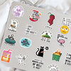 A collection of funny meme and nostalgia vinyl stickers scattered on a silver laptop surface.