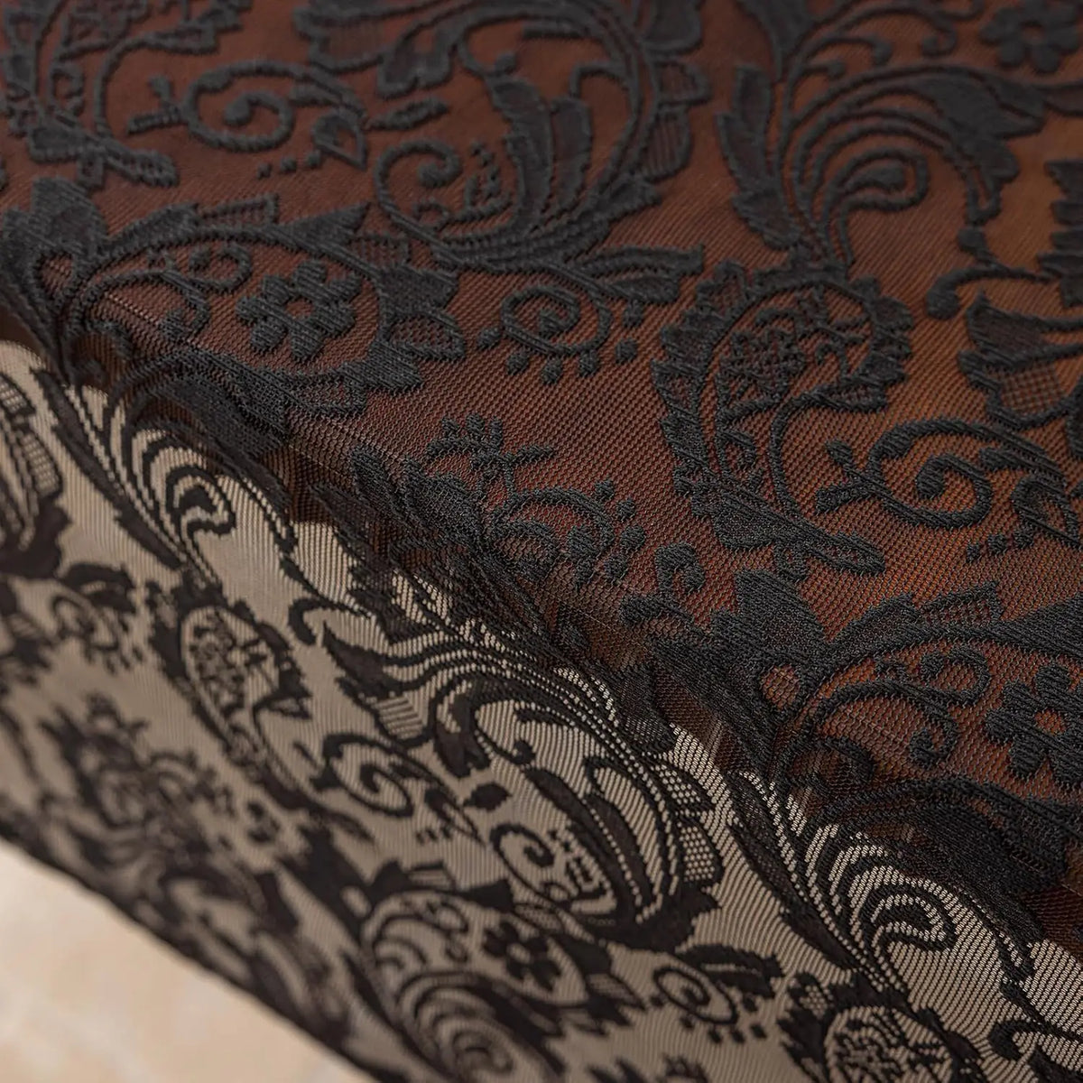 Elegant black lace tablecloth with floral embroidery shown in a close-up detail.