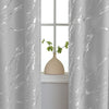 Gray curtain with white marble print framing a window view of a potted plant