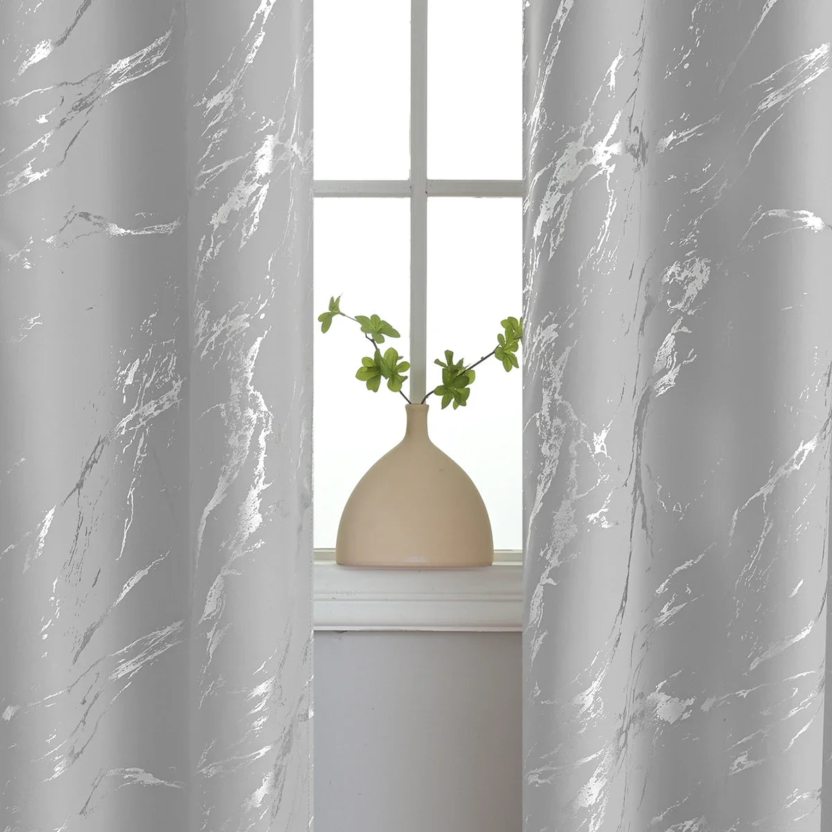 Gray curtain with white marble print framing a window view of a potted plant