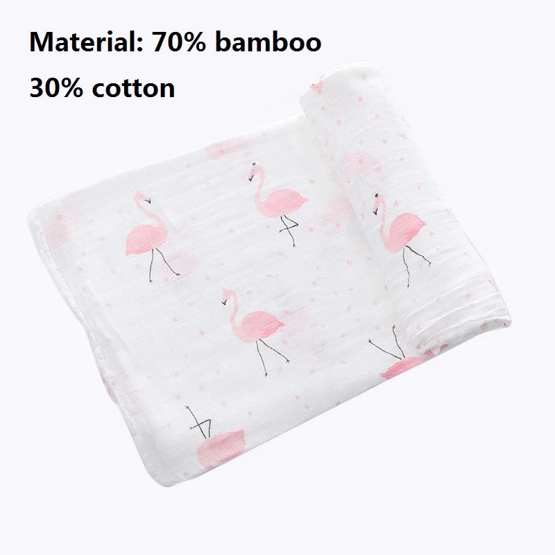 A white muslin swaddle blanket featuring pink flamingo embroidery, made from a bamboo and cotton blend.