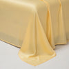 A smooth, golden yellow satin fabric draped elegantly on a table or surface.