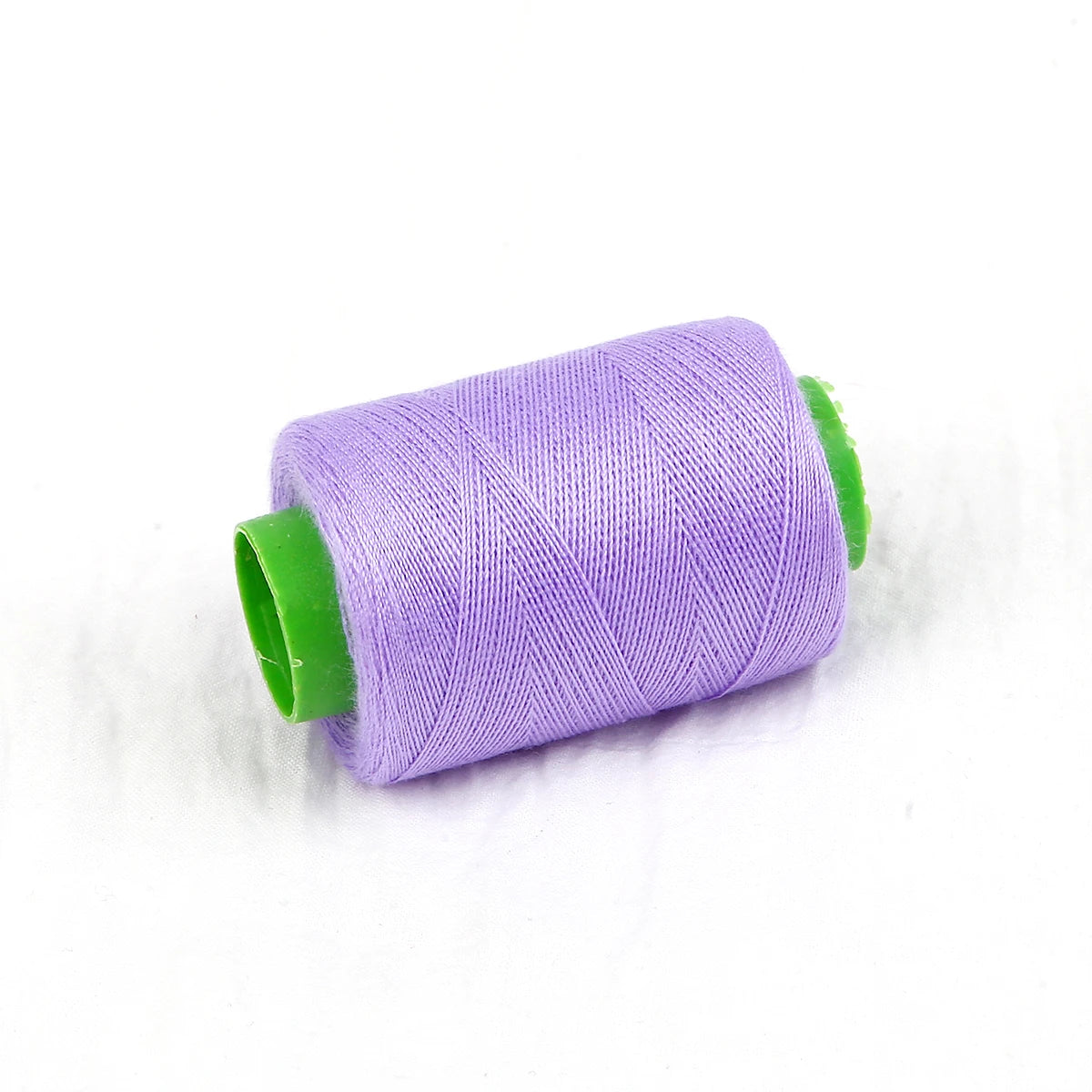 A roll of purple handmade sewing threads with green tips.