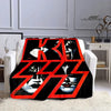 A black and red printed flannel travel blanket featuring stylized faces.