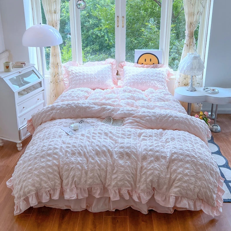 A pink lace seersucker duvet cover set displayed on a bed with white and pink bedding and natural light.