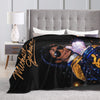 A black graphic throw blanket featuring a portrait of Michael Jackson with gold lettering.