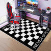 A black and white checkered gaming area rug with a neon hexagon design placed in a room setup.