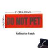 An orange reflective patch embroidered with the text DO NOT PET