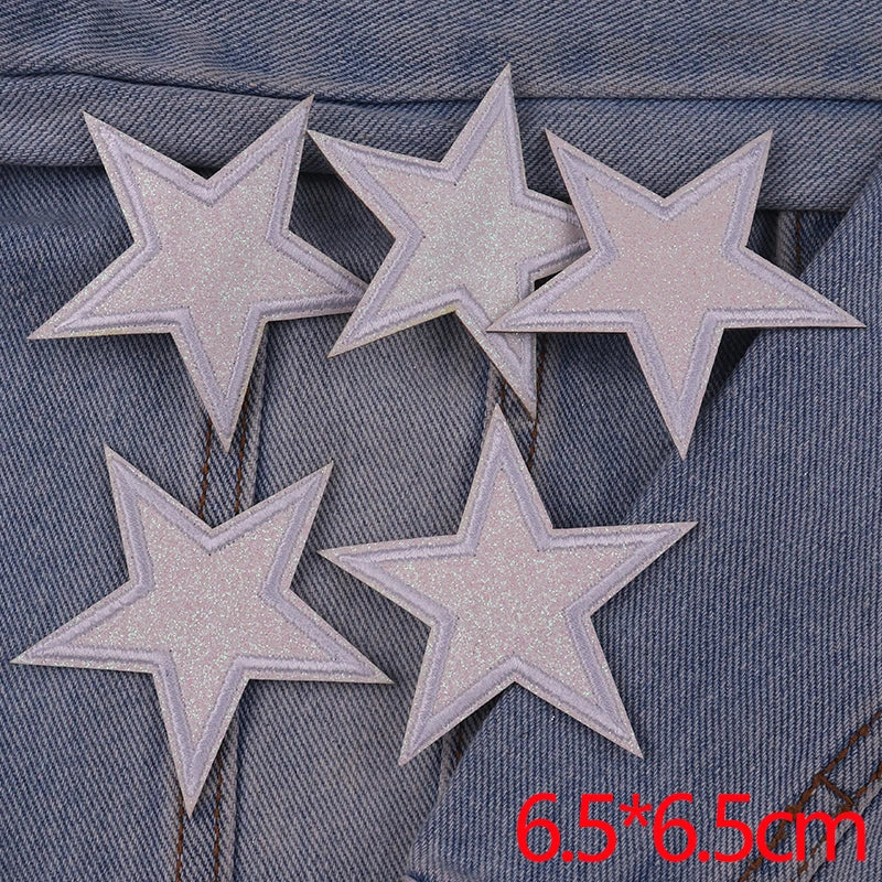 Five silver glitter star patches are displayed on a denim fabric background.