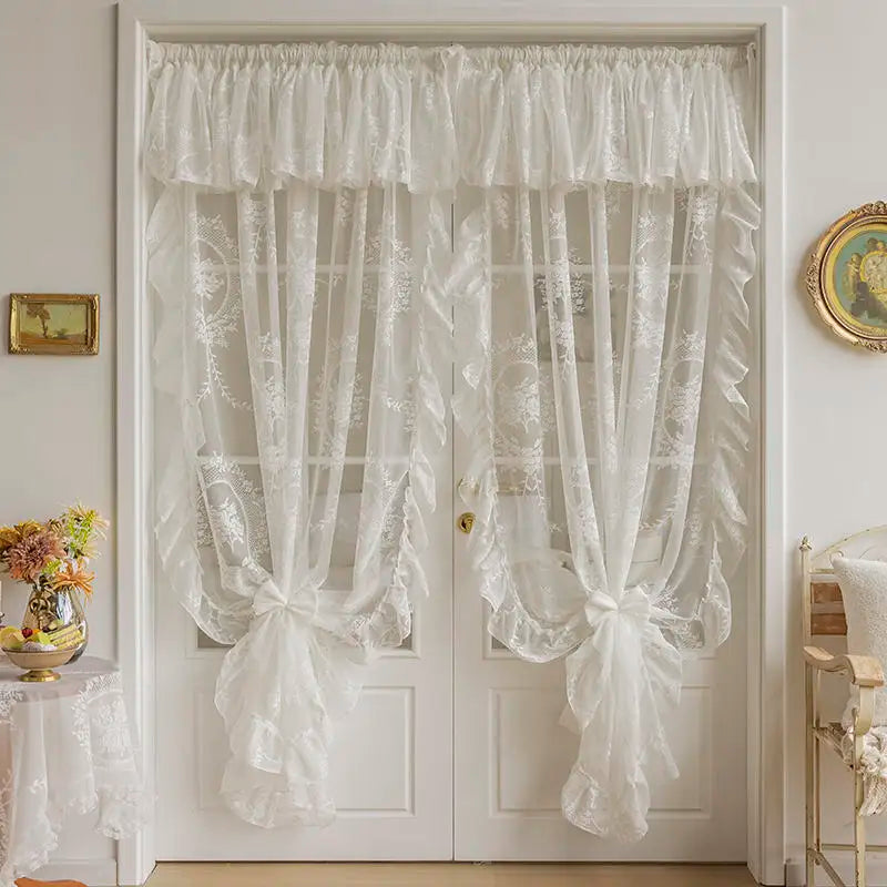 White sheer lace curtains with gathered fabric hang on a white door.