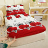 A red rose printed fitted mattress cover is being placed on a white bed frame.