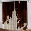 A pair of brown and white cow print curtains hanging in a doorway.