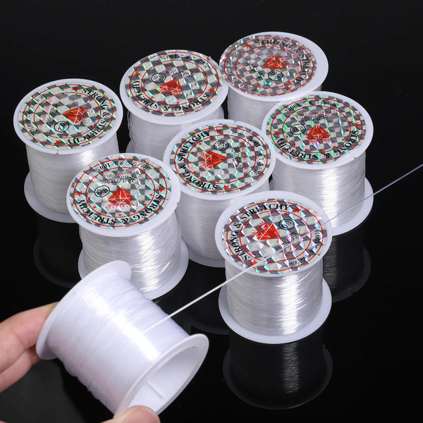Rolls of precision nylon beading thread for jewelry making stacked on a black surface.