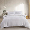 A white boho tufted microfiber duvet cover set displayed on a bed in a bright room.