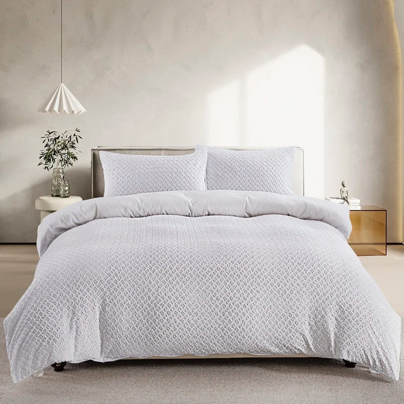 A white boho tufted microfiber duvet cover set displayed on a bed in a bright room.
