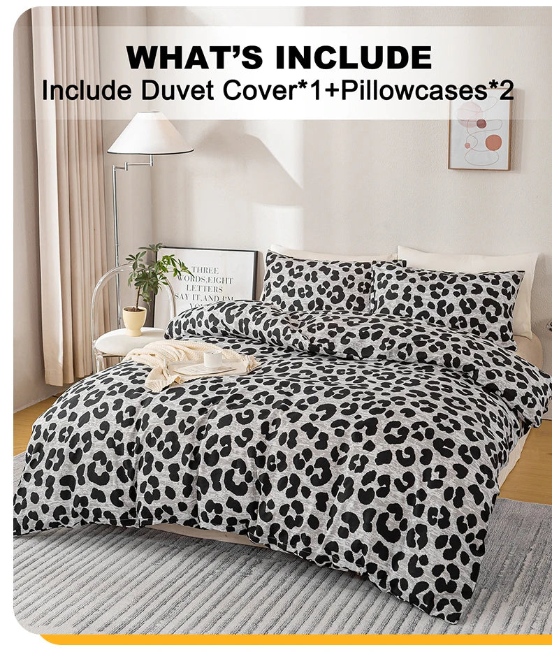 A leopard print duvet cover set featuring a black and white spotted pattern displayed on a bed.
