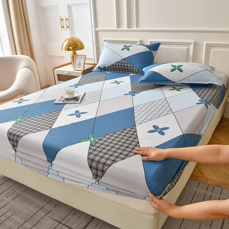 A blue and gray floral fitted sheet set with matching pillowcases is displayed on a bed.