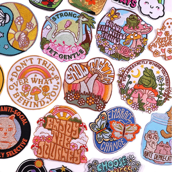 A collection of iron-on embroidery patches featuring nature and inspirational phrases like Strong Gentle and Embrace the Jour