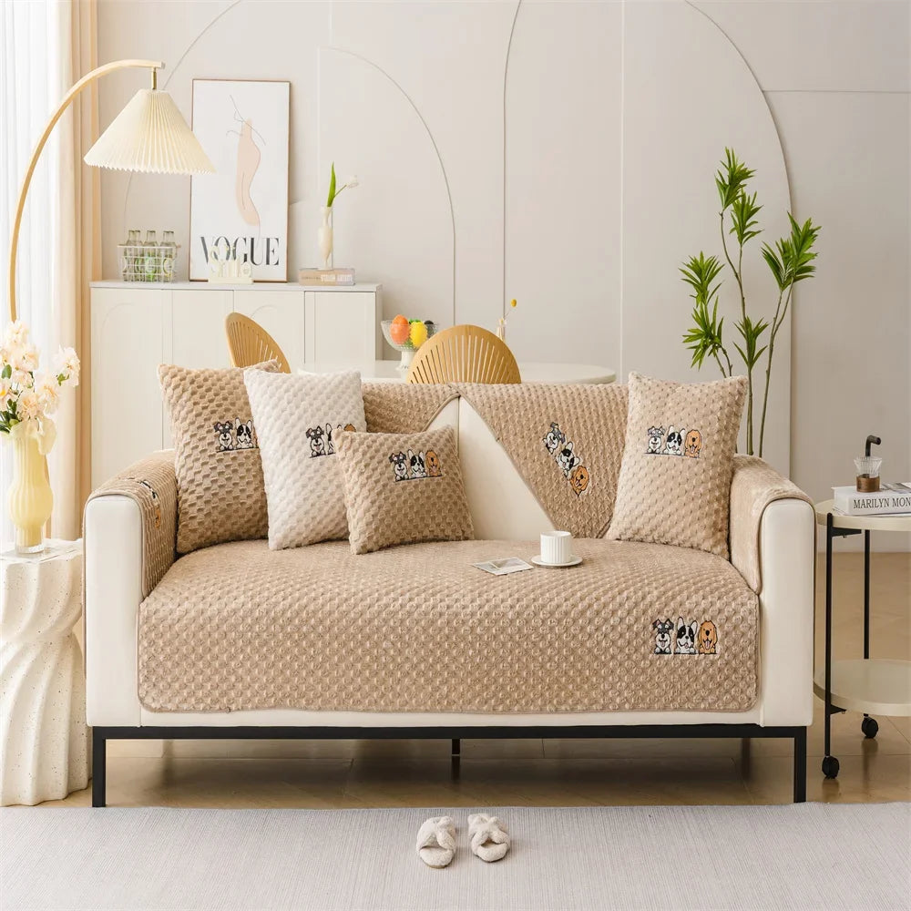A beige plush sofa cover with decorative pillows and a light wood accent in a bright, modern living room.