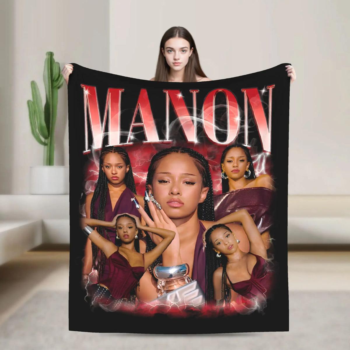 A black fleece throw blanket featuring a graphic design of the name MANON and several women.