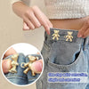 Close-up of bear button pins being used to tighten the waist of denim jeans