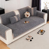 A gray sofa cushion cover with beige trim and decorative round pillows resting on a light-colored floor.