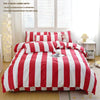 A red and white striped duvet cover set displayed on a bed with pillows and a decorative lamp.