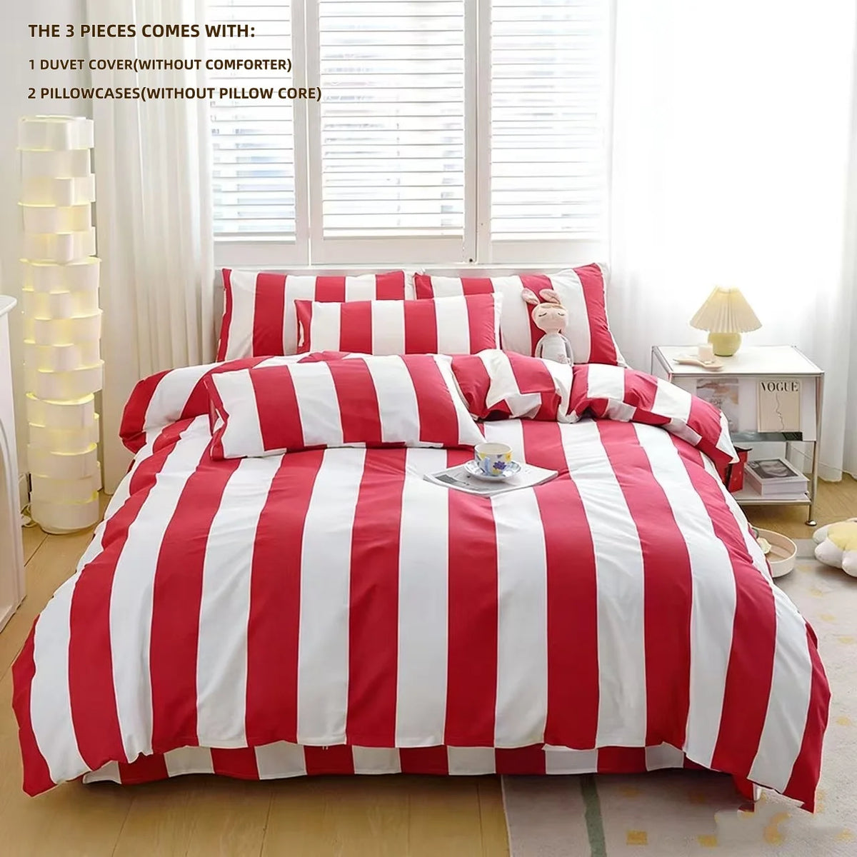 A red and white striped duvet cover set displayed on a bed with pillows and a decorative lamp.