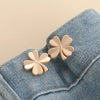 Two rose gold butterfly brooches pinned onto a light blue denim fabric.