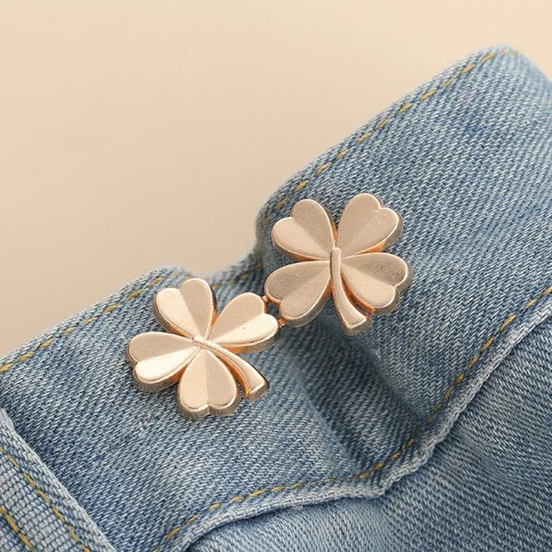 Two rose gold butterfly brooches pinned onto a light blue denim fabric.