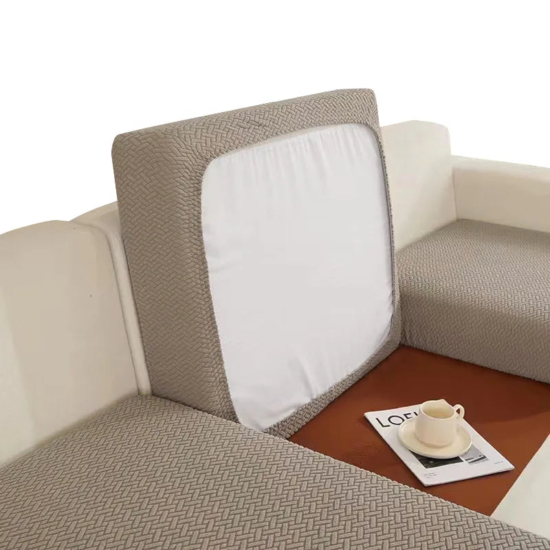 A beige sofa seat protector cushion cover with a white insert is shown on a brown table.