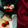 Close-up of hands knitting with red yarn, showing a texture contrast between dark and bright red knitted fabric.
