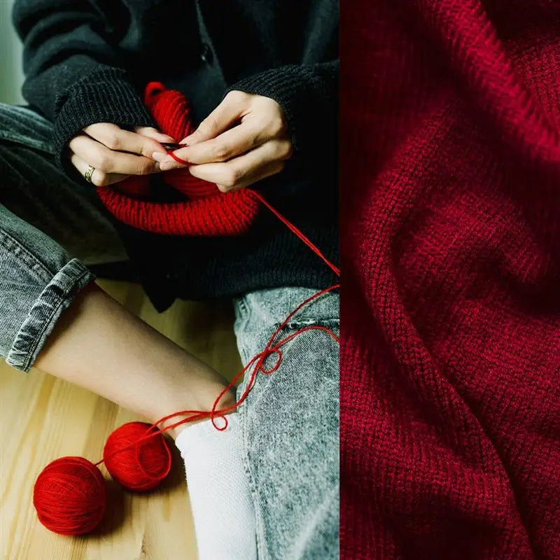 Close-up of hands knitting with red yarn, showing a texture contrast between dark and bright red knitted fabric.