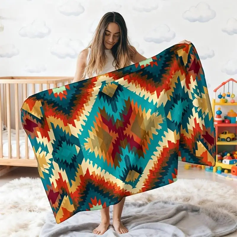 A woman models a vintage floral patchwork throw blanket featuring warm autumnal colors like orange, red, teal, and yellow.