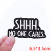 Black embroidered patch with white text reading SHHH. NO ONE CARES.
