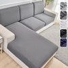 A light gray elastic sofa slipcover in a modern style shown with various fabric options.