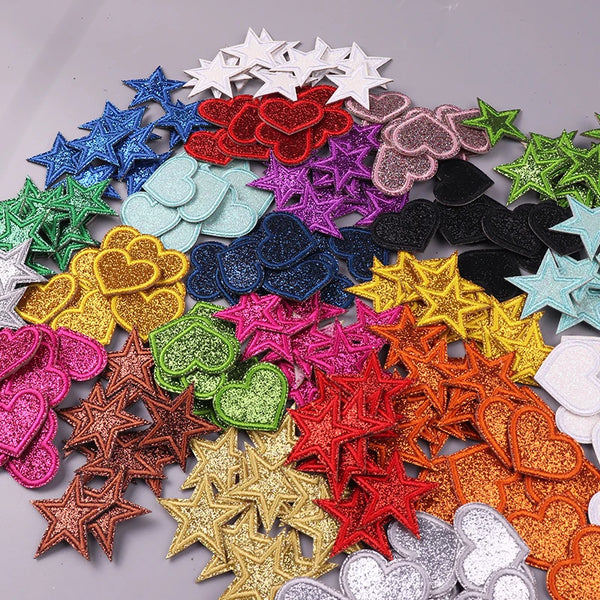 A collection of glitter iron-on embroidered love heart and star patches in various colors and shapes.