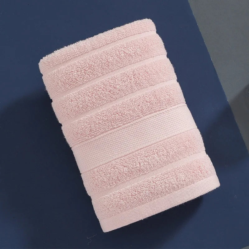 A stack of four pink, ribbed pure cotton face towels for kids and adults.