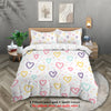 A white comforter set featuring a floral pattern with pastel hearts in yellow, pink, and green on a bed.