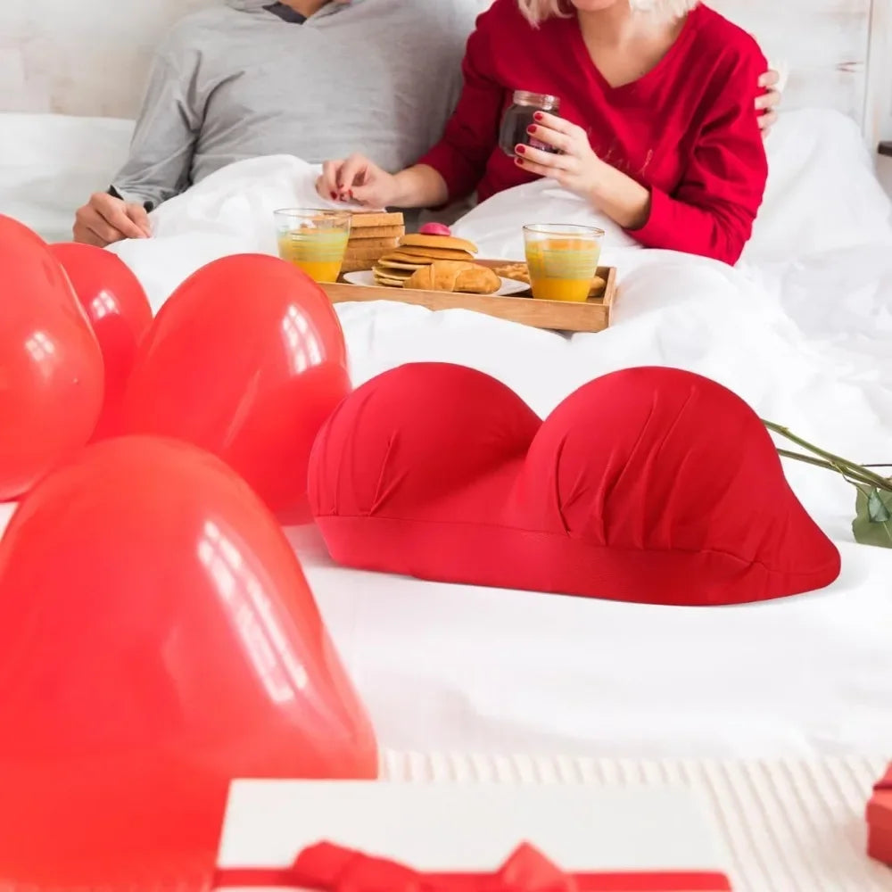 Red memory foam contour chest pillow resting on white bedding with a person nearby.