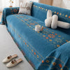 A deep blue bohemian accent sofa cover featuring geometric patterns and cream-colored decorative pillows.