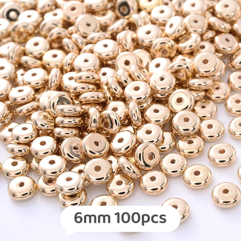 A pile of small, round, gold-colored geometric acrylic beads for jewelry making