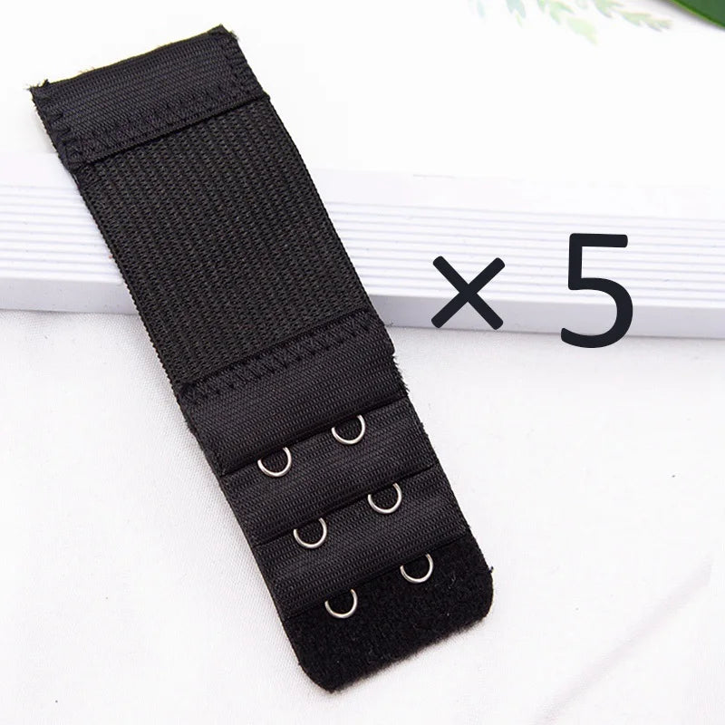 Five black adjustable bra extender straps laid out on a white surface.
